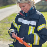 Teilnehmerin betrachtet aufmerksam die Handhabung einer Fallschirmrakete im Offshore-Sicherheitstraining