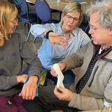 Britta unterstützt Teilnehmer beim Anlegen einer Splint-Spiegel-Schiene im Offshore-Sicherheitstraining