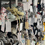 Lagerregal mit unterschiedlichen Leinen und Tauwerk, beschriftet zur Veranschaulichung der Materialkunde.